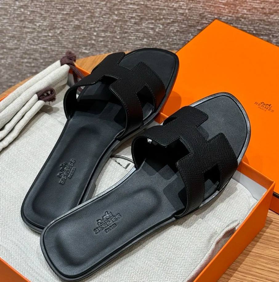 Spot Hermes leather H black flat slippers with matching black stitching – elegant women’s sandals.