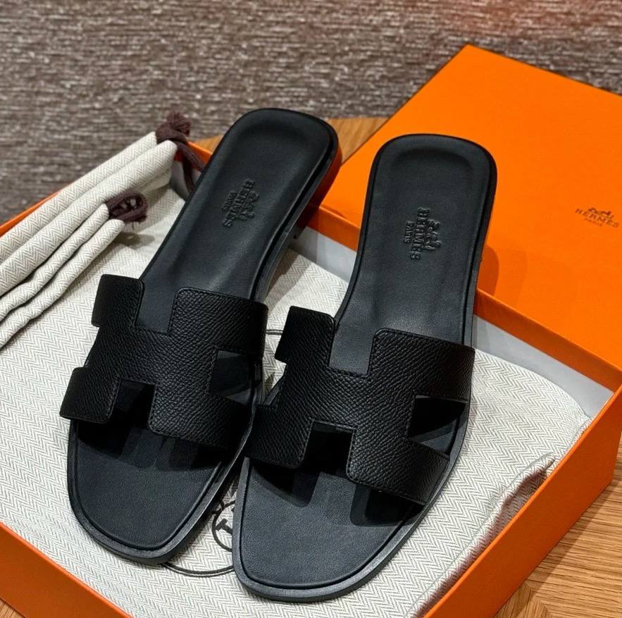 Spot Hermes leather H black flat slippers with matching black stitching – elegant women’s sandals.